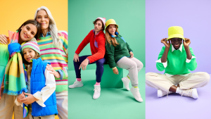 Three models wearing colorful sweaters and puffer vests, two models wearing fuzzy sweatshirts, and a model wearing a yellow bucket hat and green sweater.