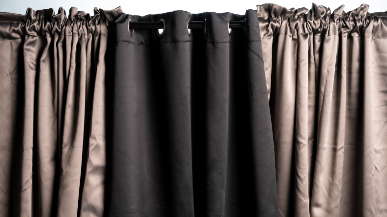 three curtains hanging together, side ones are a shiny gold middle one is darker