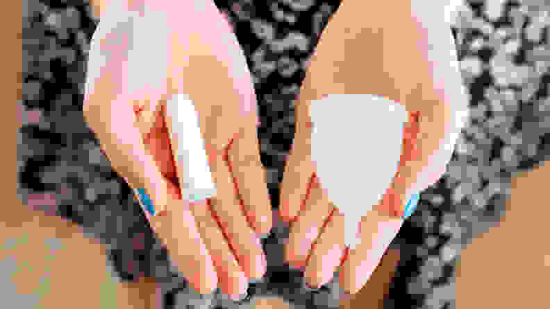 Female hands holding menstrual cup and medical tampon close up