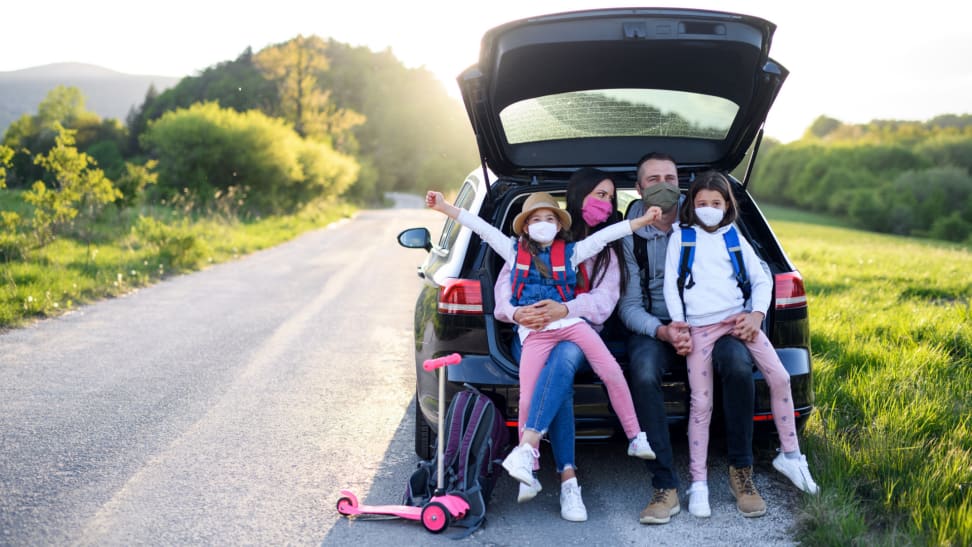 A family wears face masks during a road trip.