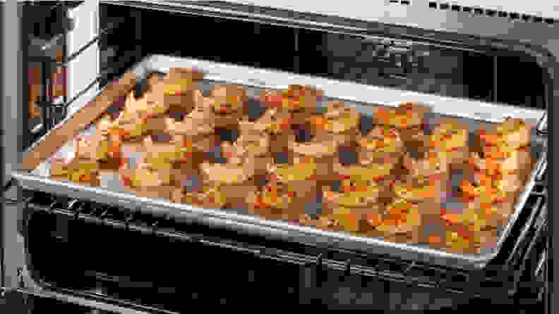 A tray of shrimp on a tray in the open oven of the GE Cafe C2Y486P3TD1.