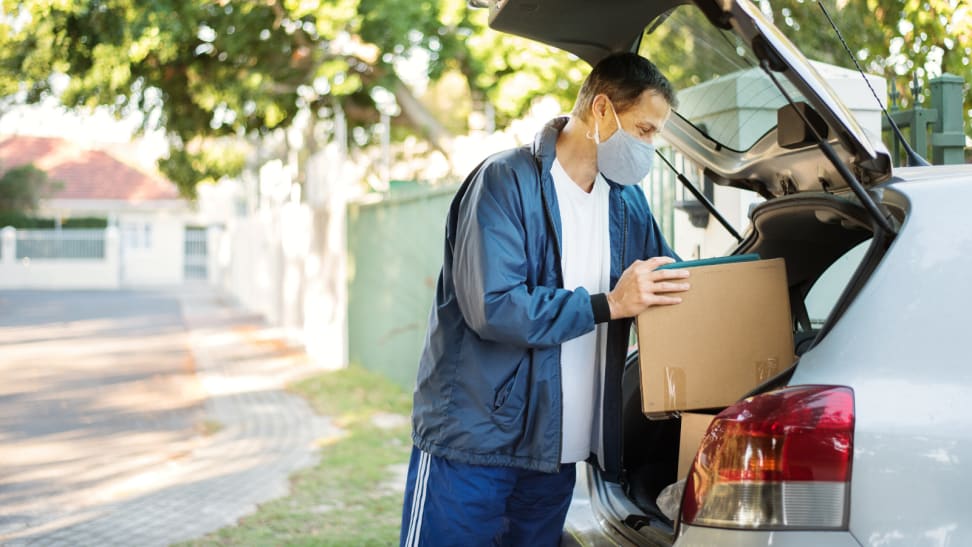 Man putting a box in his trunk