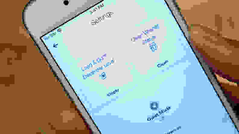 A close-up of a white iPhone with the Whirlpool app open. The user, is looking at information about their detergent levels