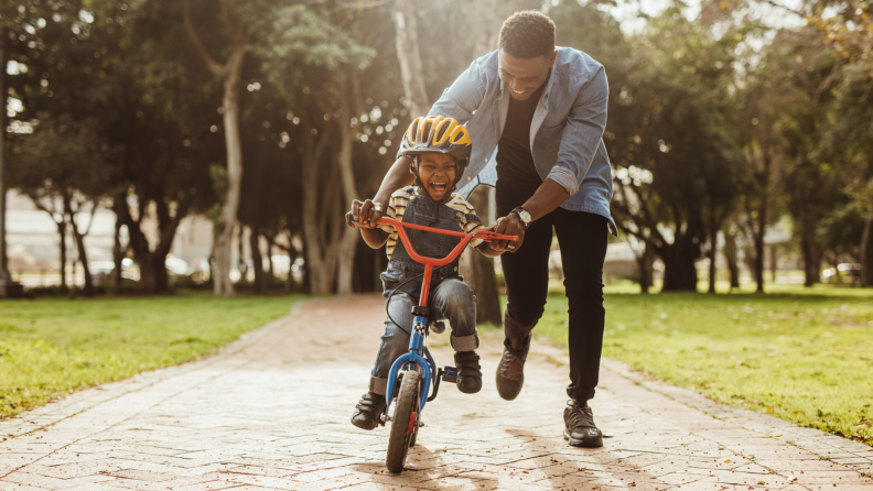 Father helping son learn to ride a bike