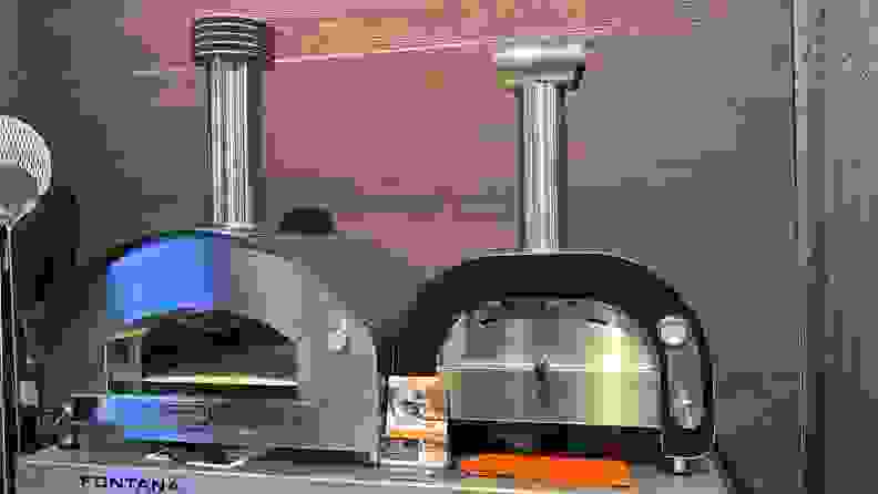 Two metal pizza ovens on a display