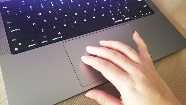 Fingers resting on a laptop's trackpad