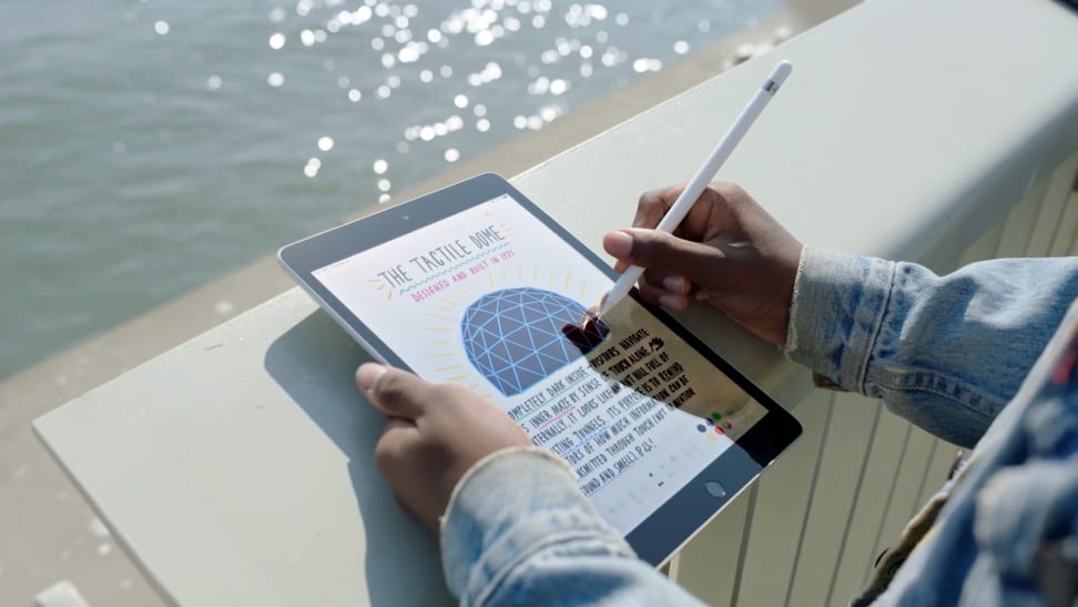 A man holding an iPad and Apple Pencil in the sunlight