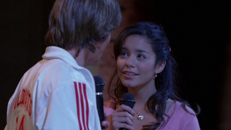 A still from 'High School Musical' featuring Gabriella singing with Troy onstage.