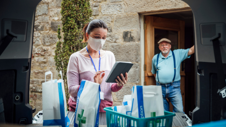 An elderly man receives a prescription delivery.