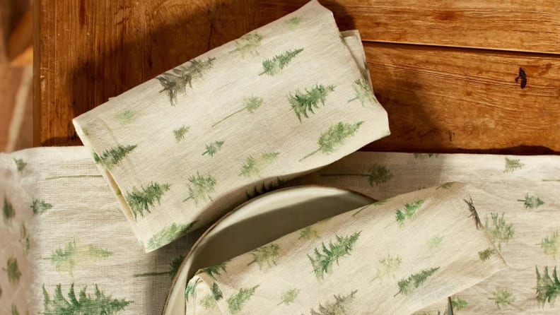 Christmas tree-themed cloth napkins on wooden surface