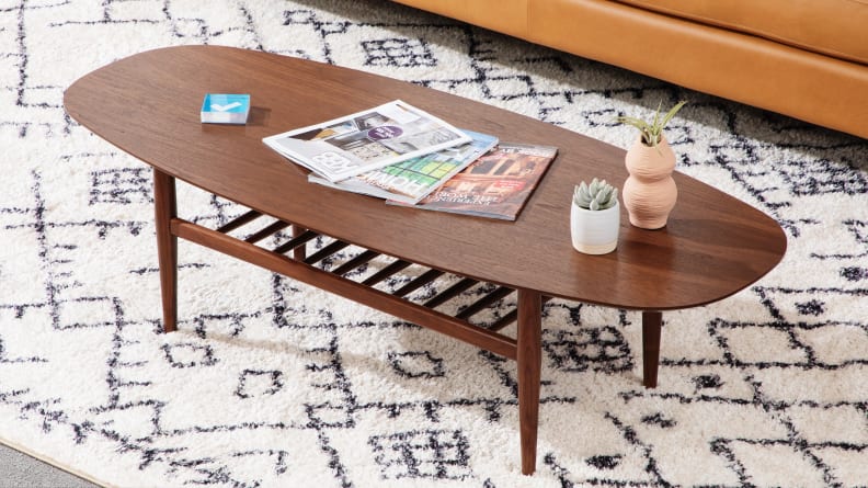 Lenia Walnut Oval Coffee Table on top of rug in living room space.