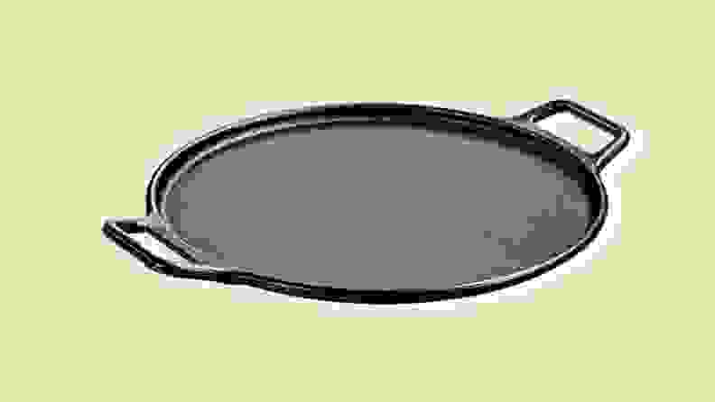 A pizza stone with handles on a beige background.
