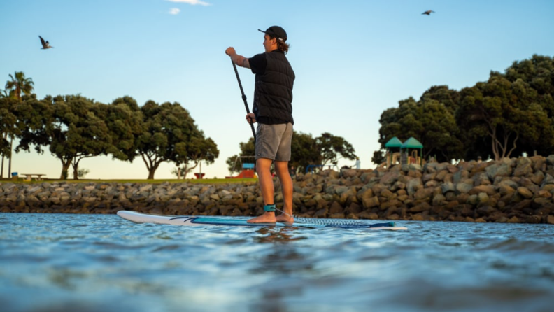 A man paddling on a board.