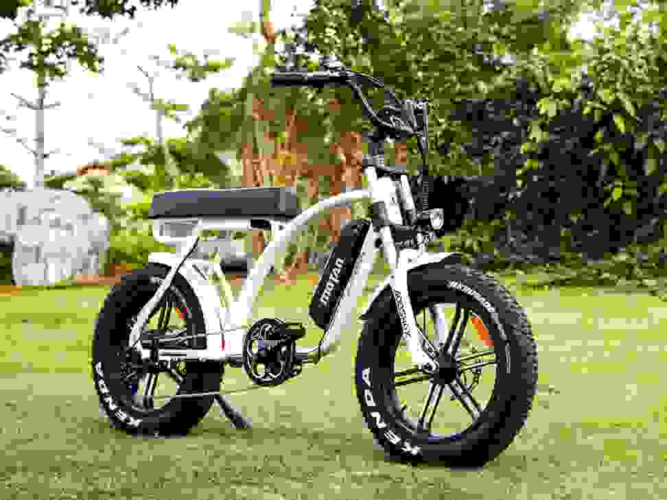 Photo of a white Addmotor electric bike parked in the grass.
