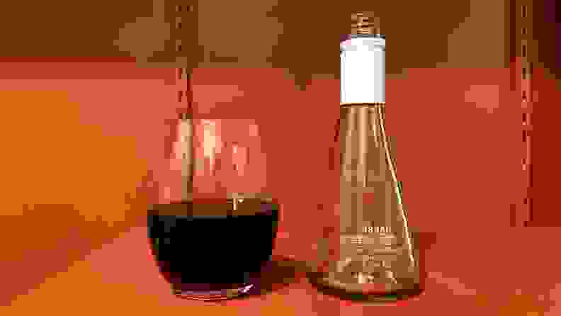 A Usual Wines bottle emptied into a wine glass, which is over halfway full.