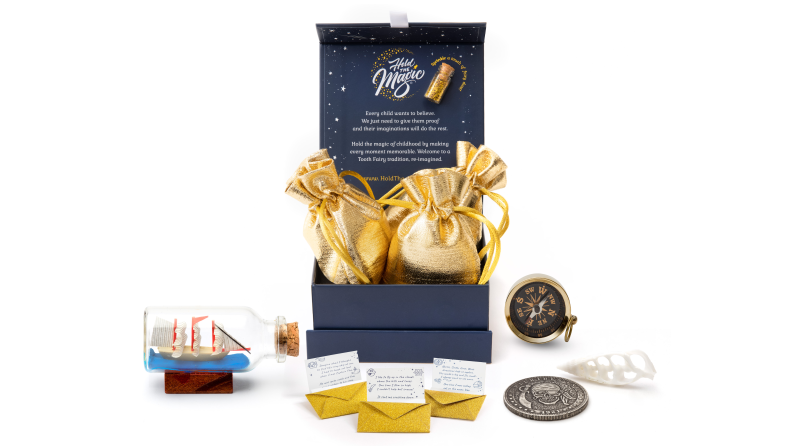 A box holding three gold pouches, a tiny ship in a bottle, and a tiny compass