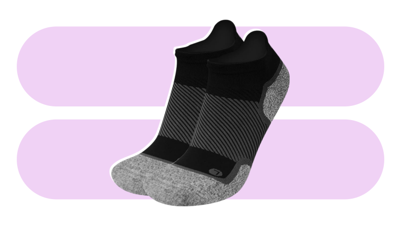 A pair of black and gray Orthosleeve socks against a purple background.