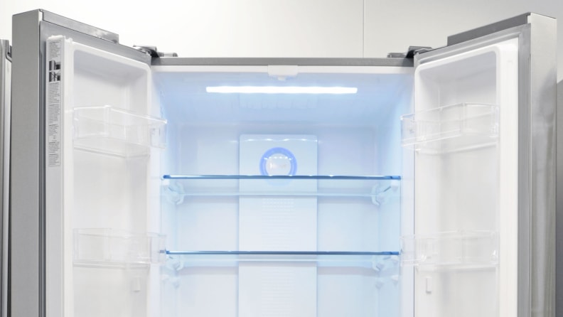 A close-up of the interior of the Haier HRF15N3AGS fridge. Its doors are wide open, revealing all the door storage and shelving.