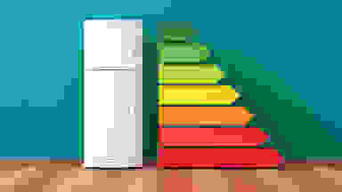 A top-freezer fridge stands next to a series of stacked lines along its right side. The lines have arrow-shaped ends pointing to the right, and are stacked with the greenest and smallest arrow on top, and the longest, reddest arrow at the bottom.