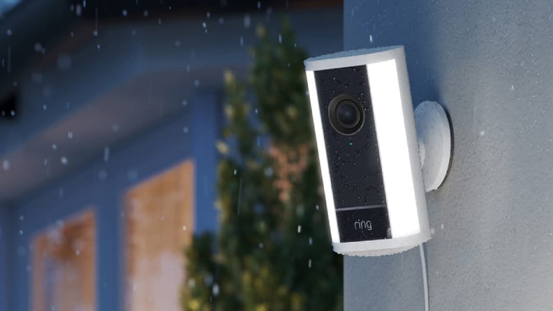 Black and white ring camera next to window