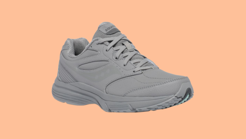 A gray sneaker against an orange background.