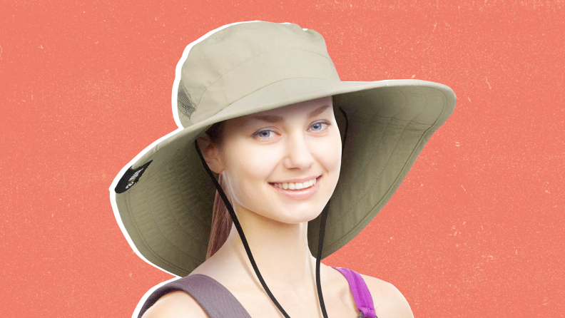 A woman wearing a sun hat against a red background.