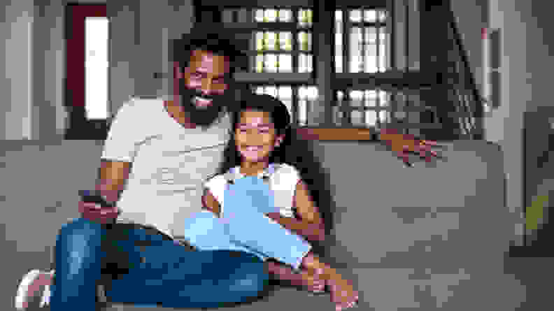 Shot of an adorable little girl watching tv and spending time with her father at home