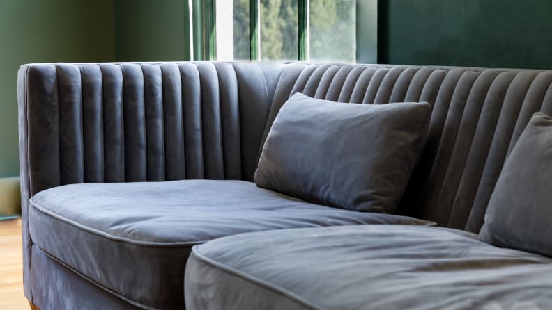 A grey couch in a dark green room