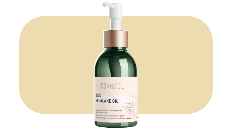 Biossance face oil in front of a mustard-colored background.
