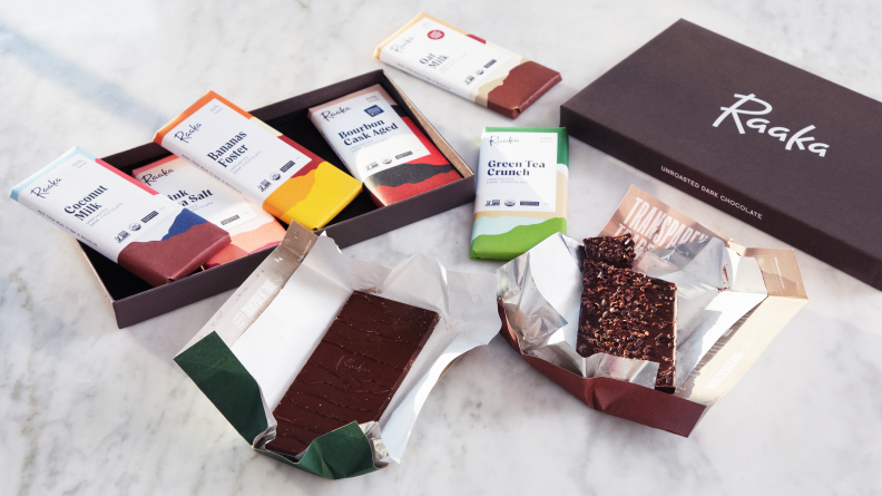 Several opened chocolate bars alongside Raaka chocolate box