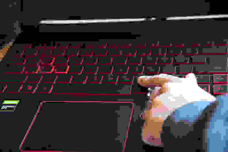 A person points to a key on the keyboard