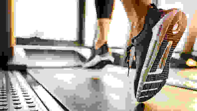 A close up of a woman's feet as she runs on the treadmill.