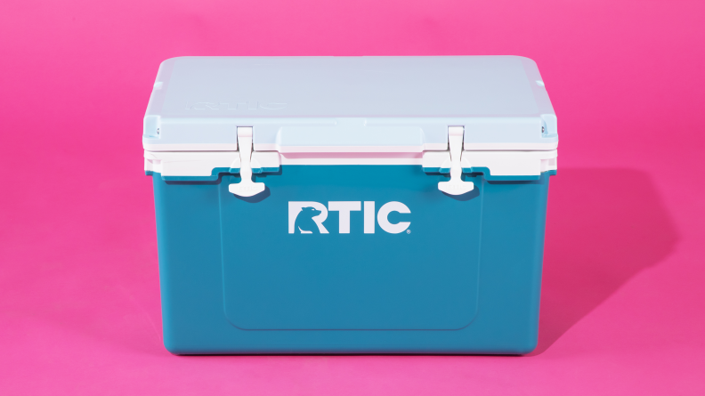 A blue Rtick cooler against a pink background.