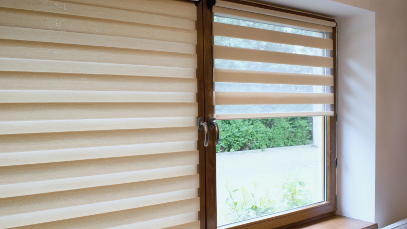 Tan window roller on a wooden window pane