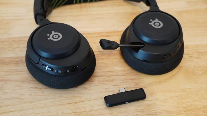 Close-up of the steelseries Arctis Nova 5x Wireless headphones and the receiver.