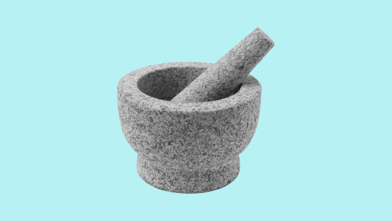 Mortar and pestle against cyan background