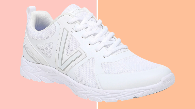 White Vionic sneakers on a pink and orange background