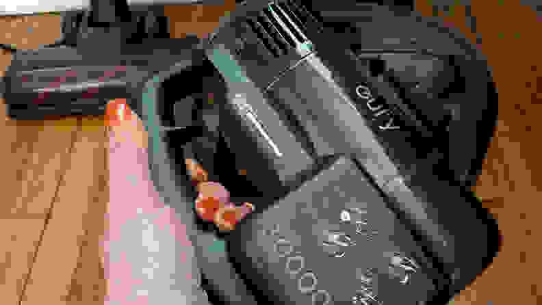 A hand holding a hand-held vacuum