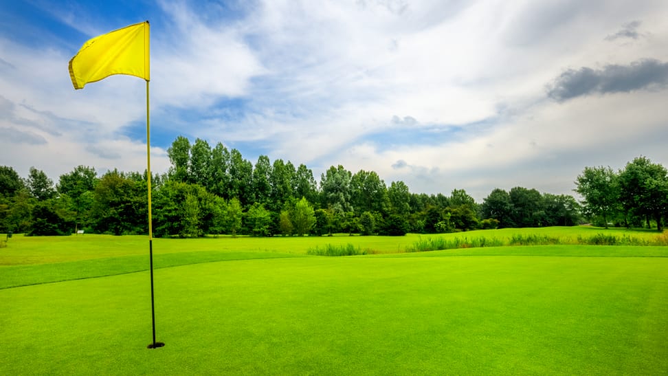 A yellow flag at the 18th hole on a golf course