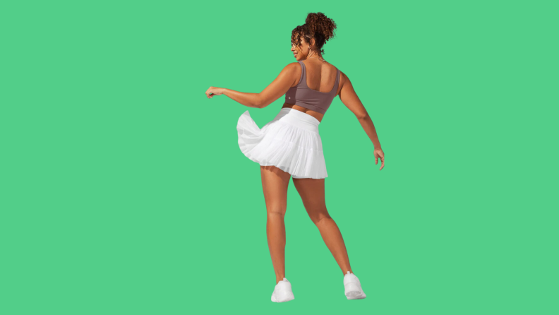 A model wearing a flowy white short skirt.