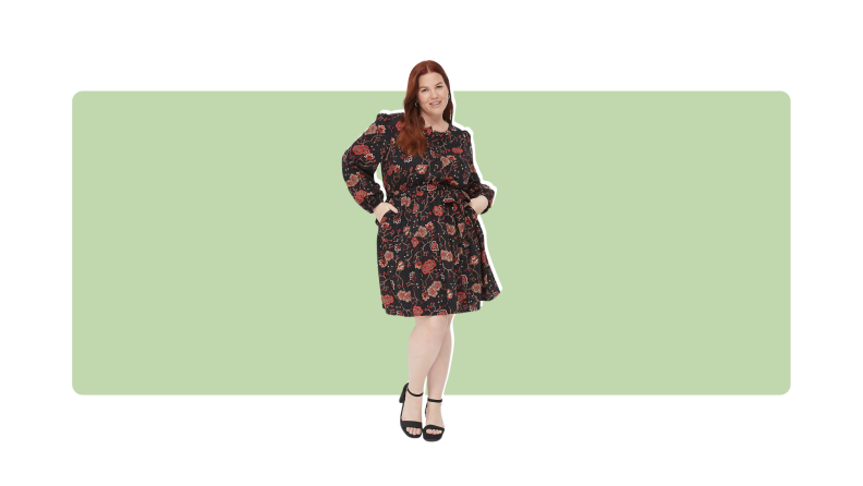 A black knee-length dress with a floral red print.