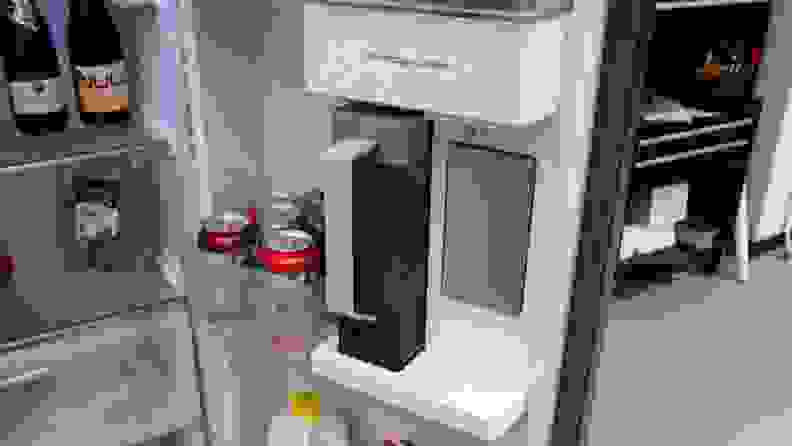 Gray auto-refilling water pitcher placed into the beverage center in the door of the Samsung RS28CB7600 side-by-side Bespoke refrigerator.