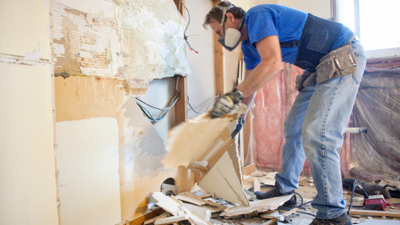 A person removes drywall.