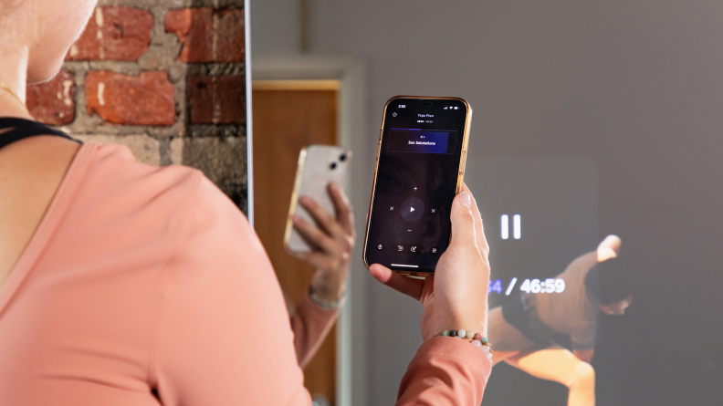 A woman selecting a Fiture workout class on her phone.