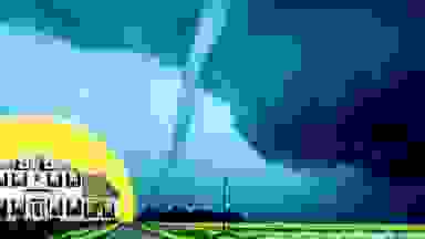 A white-colored home in front of a yellow, circular background opposite a large tornado