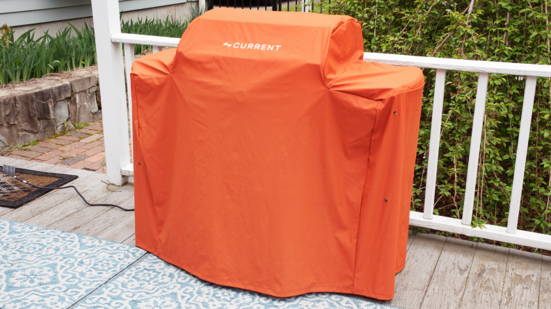 The Current grill covered by an orange cover.