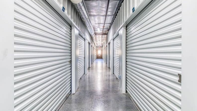An empty corridor of a silver-colored indoor self-storage facility