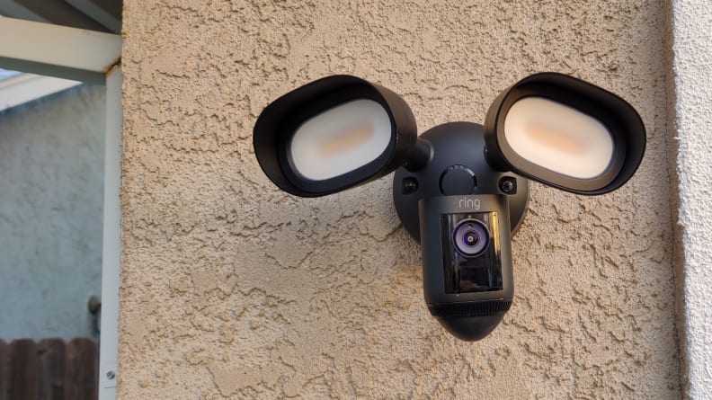 The Ring Floodlight hangs on the exterior of a beige stucco home