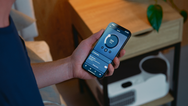 A person adjusts the Chilipad Dock Pro temperature settings using a smartphone app.