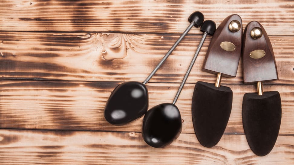 pair of plastic and wooden shoe trees lying on top of a rustic wood countertop